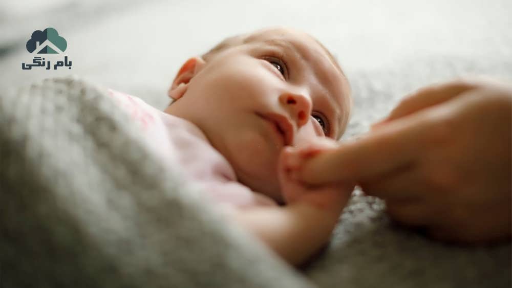 نوزاد دست مادرش را نگه داشته