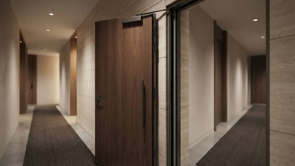 درب ضد حریق مدرن و مهندسی شده در راهروی یک ساختمان لوکس، مجهز به نوارهای درزگیر کنترل دود برای حفظ ایمنی و جان ساکنان